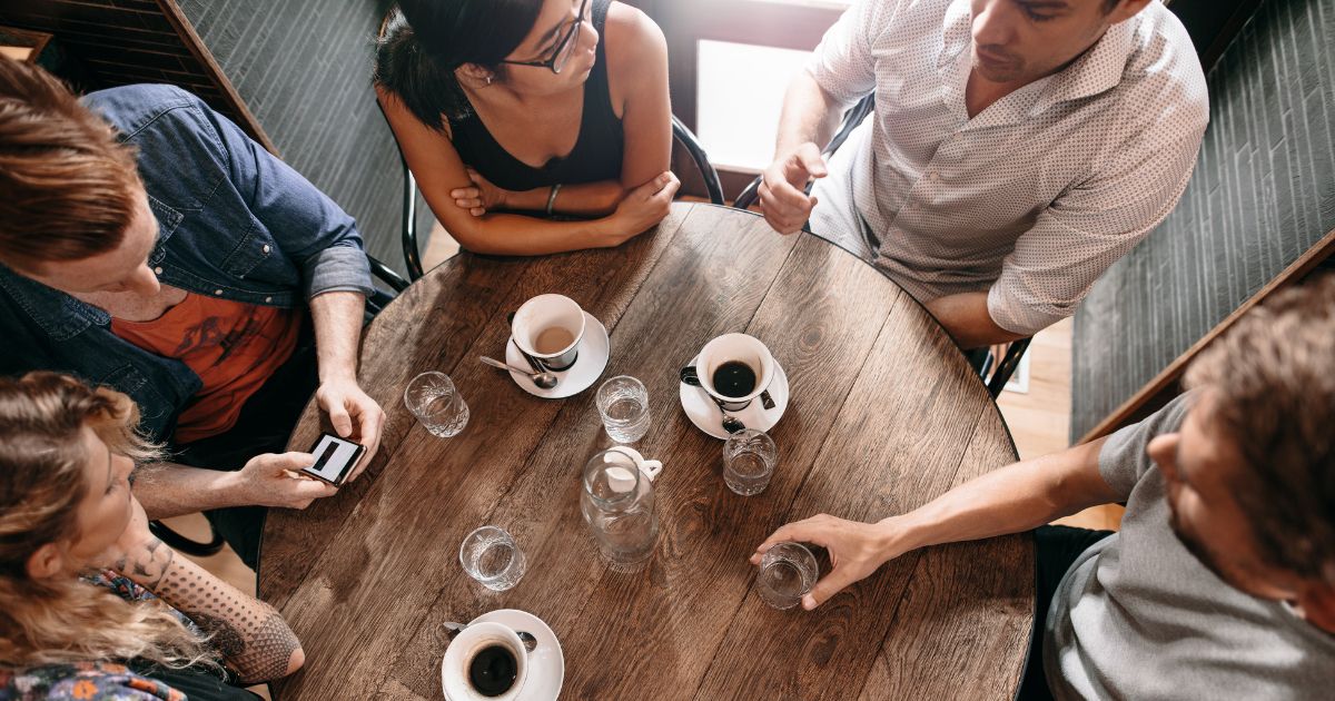 Ein Tisch mit Kaffee und sich unterhaltenden Menschen