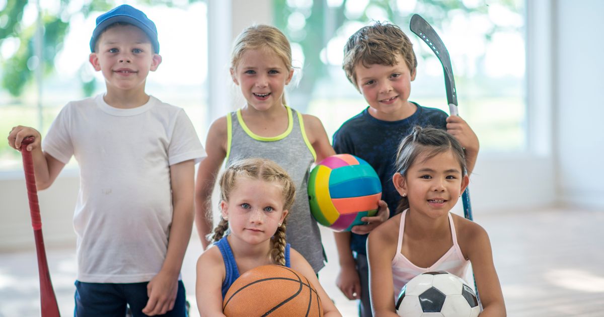 5 Kinder halten verschiedene Bälle