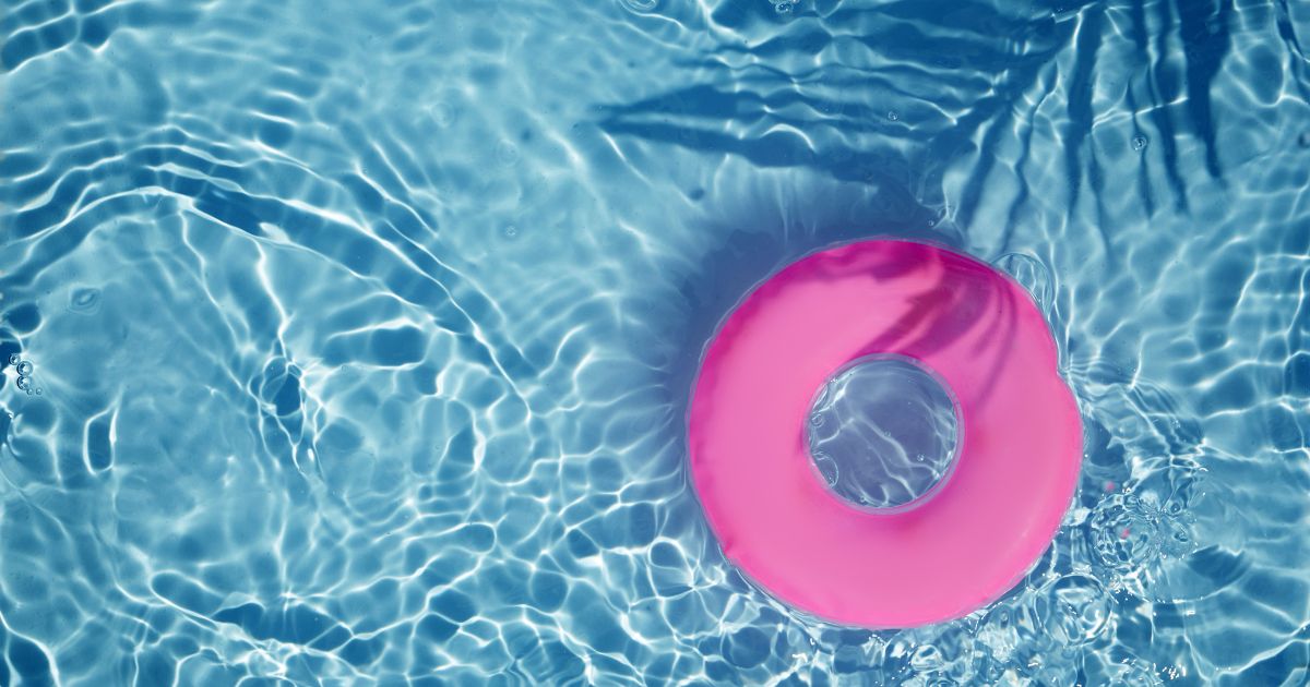 Pinker Schwimmring schwimmt auf türkisem Wasser