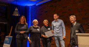 Innenministerin des Landes S-H Magdalena Finke, Ulrike Feige (Tausendfüßler Stiftung), Anke Kehrmann-Panten (Tausendfüßler Stiftung), Daniel Sandersen (Tausendfüßler Stiftung) & Landespastor Heiko Naß (Diakonievorstand) auf der Bühne mit Spendencheck über 3.000,-€