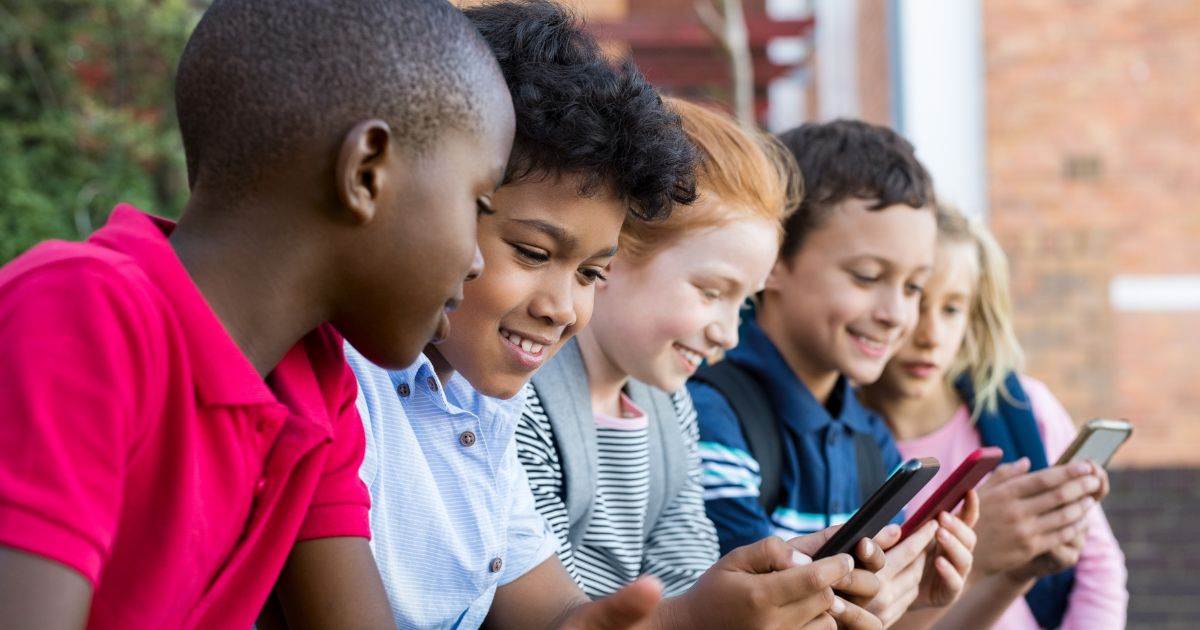 Gruppe von Kindern schaut sich Dinge auf dem Smartphone an