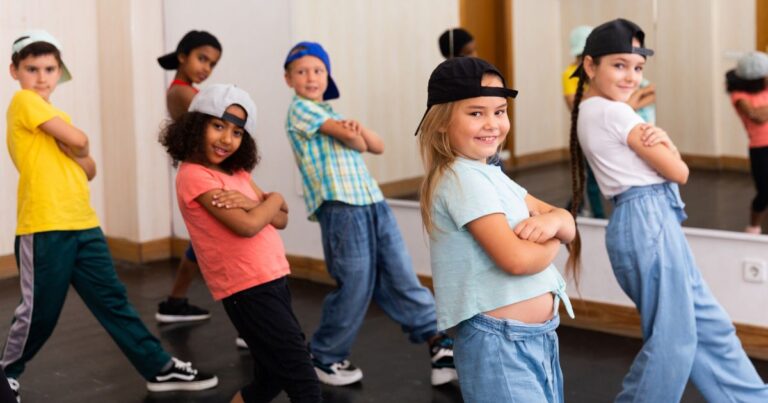 Kinder in einem Raum mit Spiegel stehen in einer tänzerischen Pose
